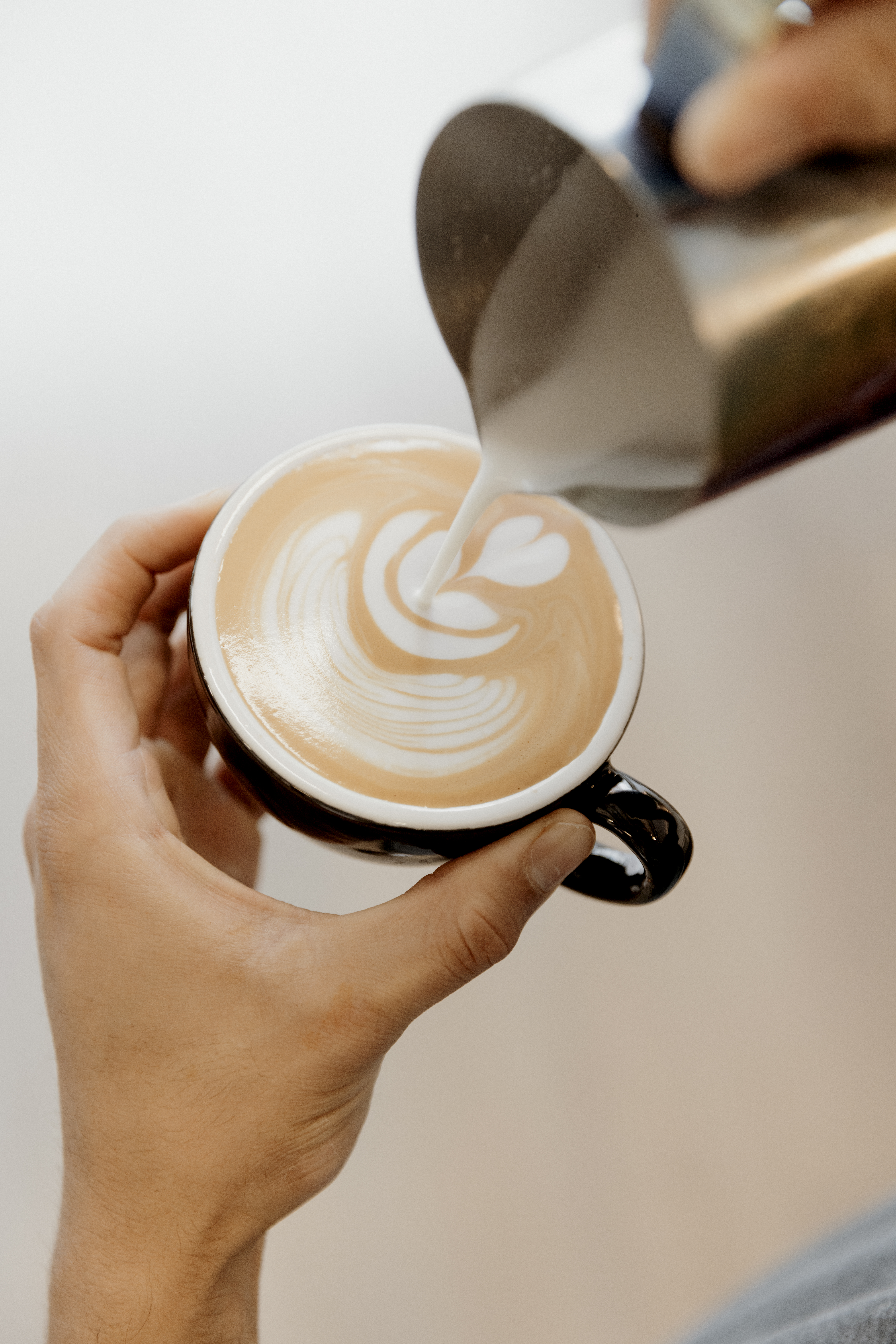 Award-winning barista pouring latte art at ARVO Specialty Coffee Bilbao